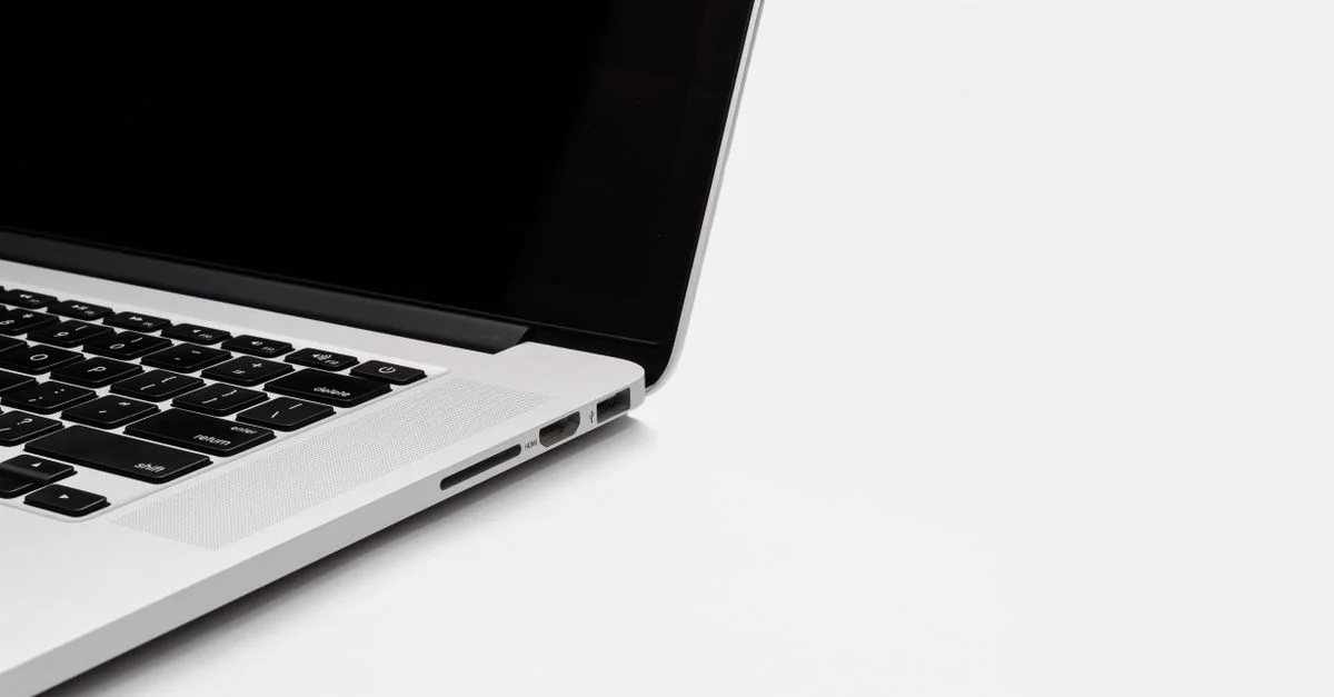 Gros plan sur un clavier et un écran d'ordinateur portable élégants sur un fond blanc. Parfait pour du contenu lié à la technologie.
