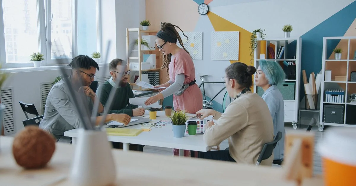 Un environnement de bureau moderne où une équipe diversifiée collabore et partage ses idées avec enthousiasme.