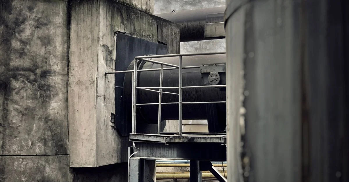 Vue détaillée d'une architecture industrielle mettant en avant des structures métalliques, des tuyaux et du béton texturé à Chengdu.