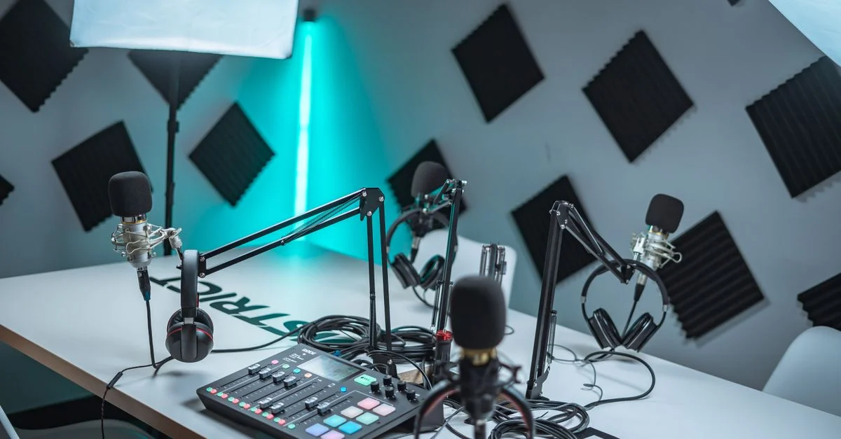 Configuration élégante de studio de podcast avec microphones, mixeur audio et panneaux acoustiques.