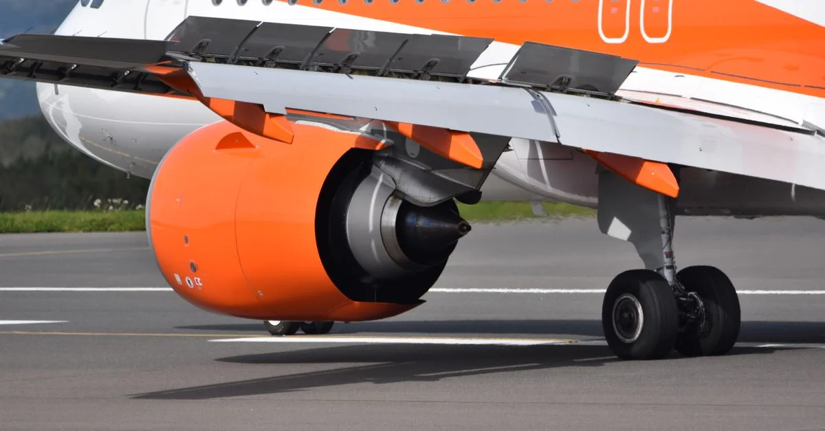 Gros plan d'un avion EasyJet sur la piste mettant en avant le moteur et le train d'atterrissage.