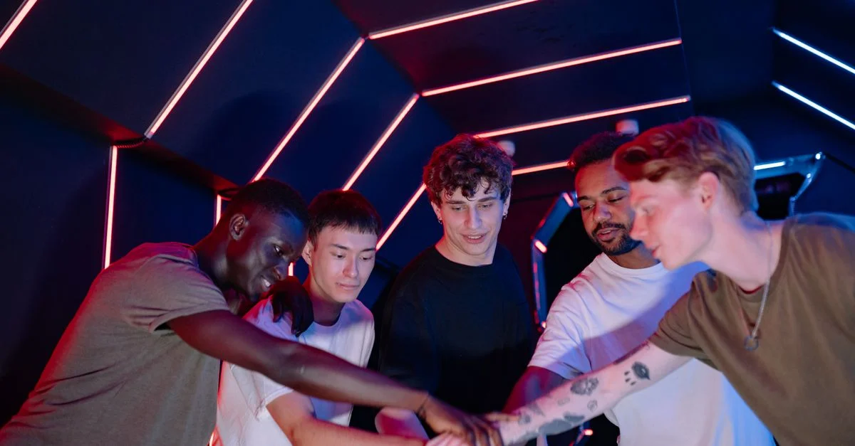 Un groupe diversifié de jeunes amis se réunissent dans une chambre futuriste éclairée au néon, symbolisant le travail d'équipe.