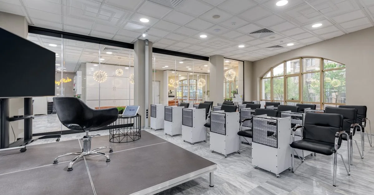 Salle de conférence spacieuse avec podium, chaises et cloisons en verre aux éléments de design moderne.