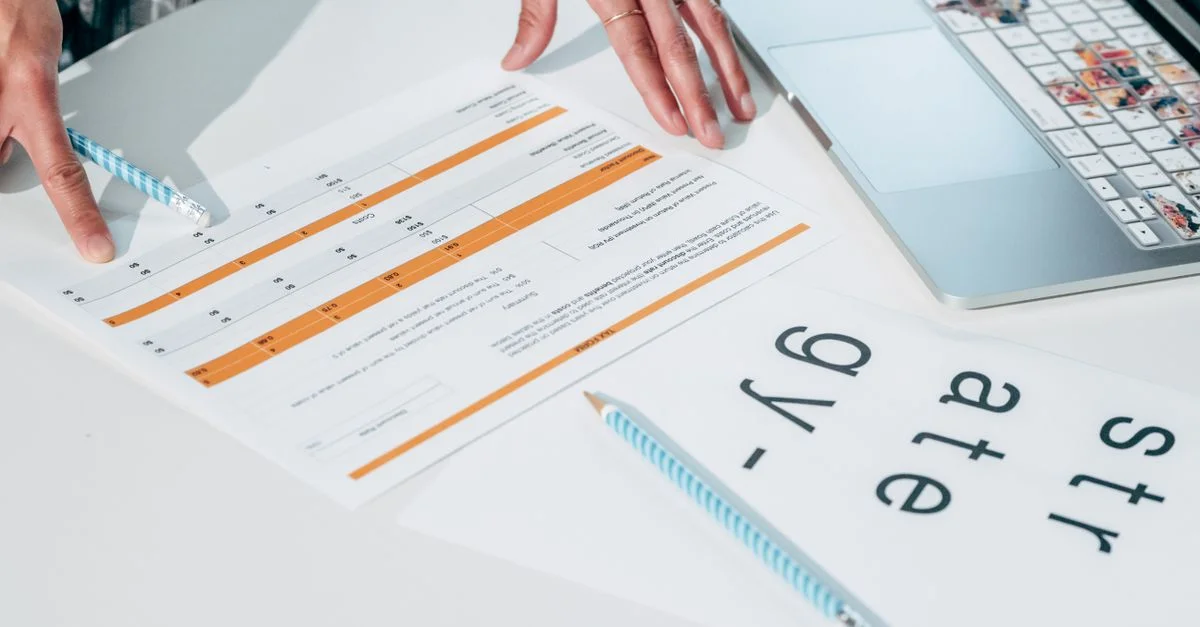 Gros plan sur des mains examinant des documents d'affaires et des papiers de stratégie sur un bureau de bureau.
