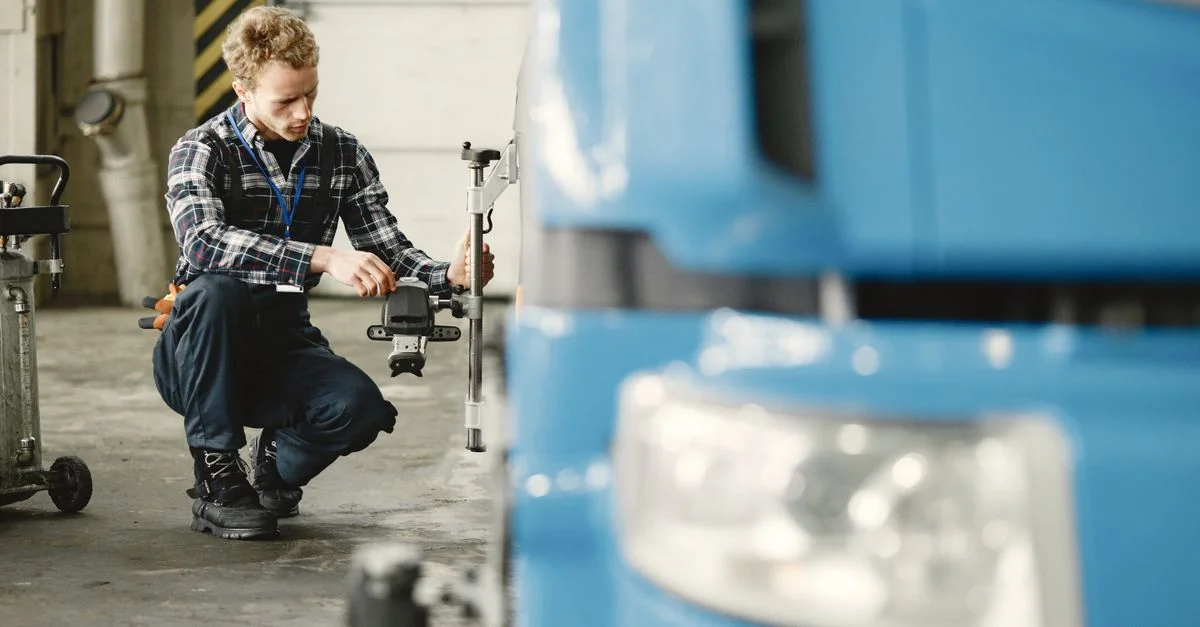 Mécanicien ajustant les roues d'un camion dans un atelier, mettant en avant la précision et le savoir-faire.