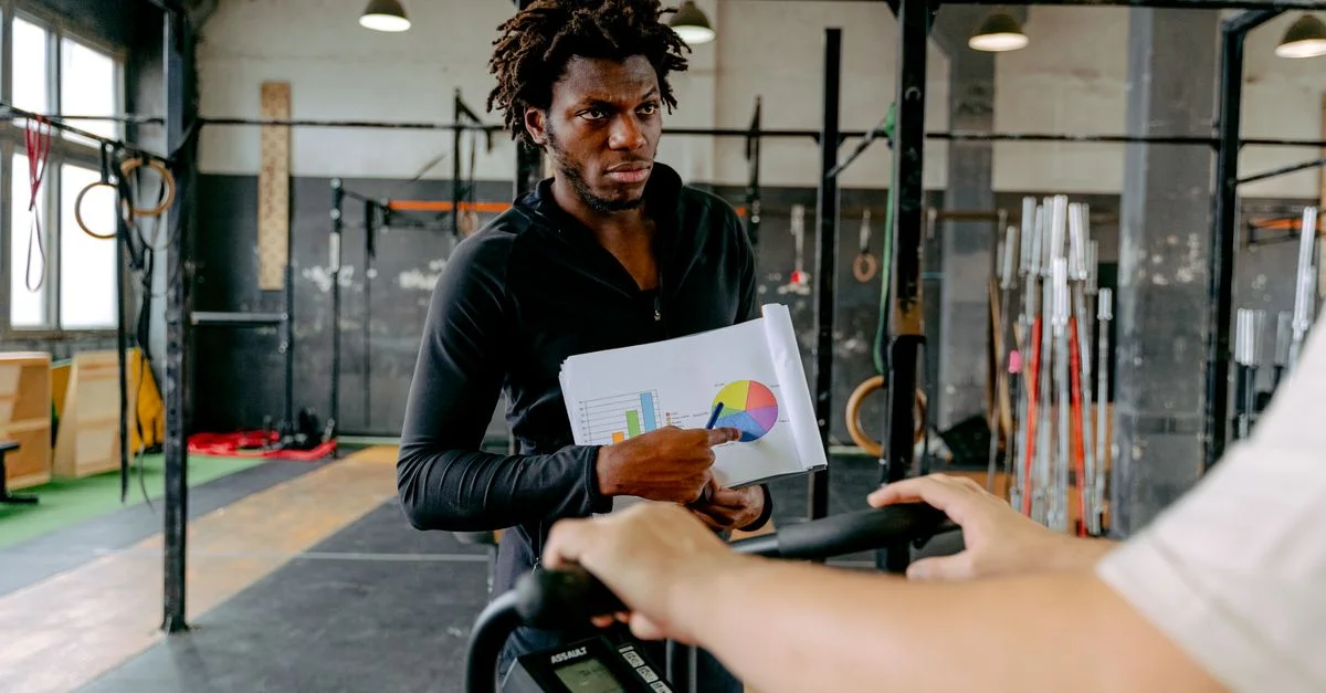 Un entraîneur personnel guide un client lors d'une séance d'entraînement à la salle de sport.