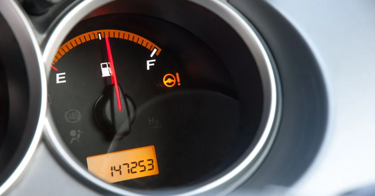 Gros plan détaillé d'un affichage de carburant d'une voiture avec un compteur indiquant une lecture de 147253 miles.