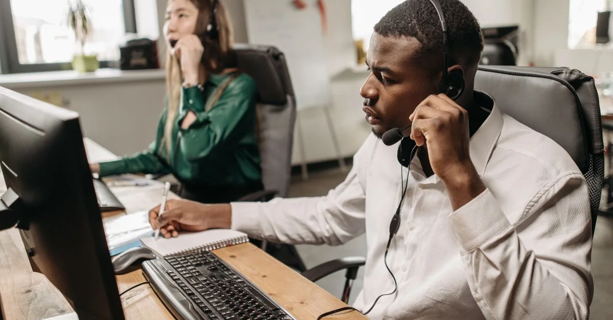 Une équipe concentrée de représentants du service client travaillant sur des ordinateurs et répondant à des appels dans un bureau