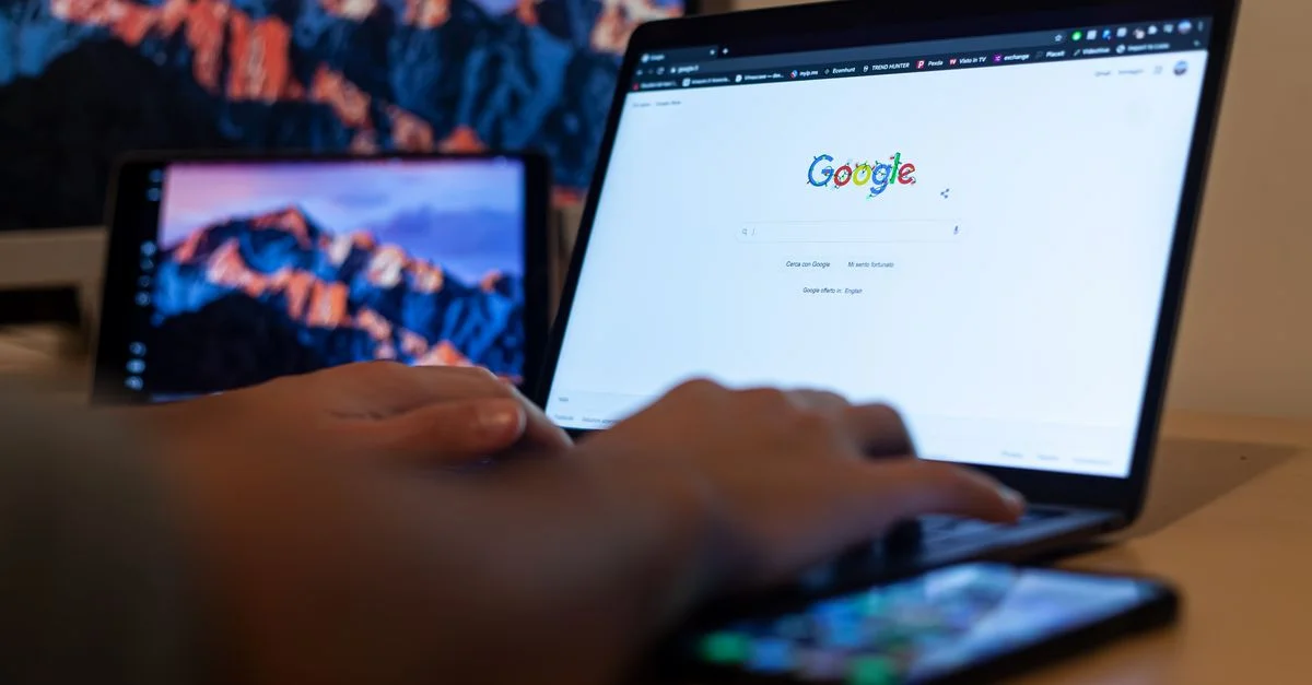 Mains tapant sur un ordinateur portable avec Google à l'écran, dans un environnement de travail à distance à Milan, en Italie.