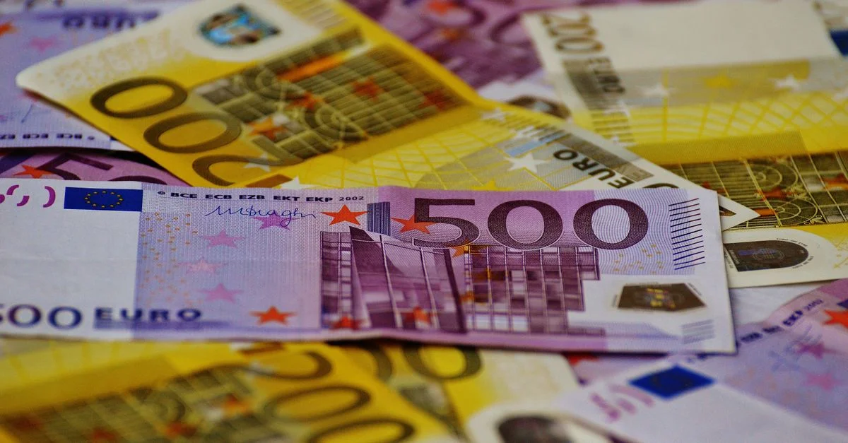 Une image en gros plan de plusieurs billets en euros disposés de manière éparpillée.