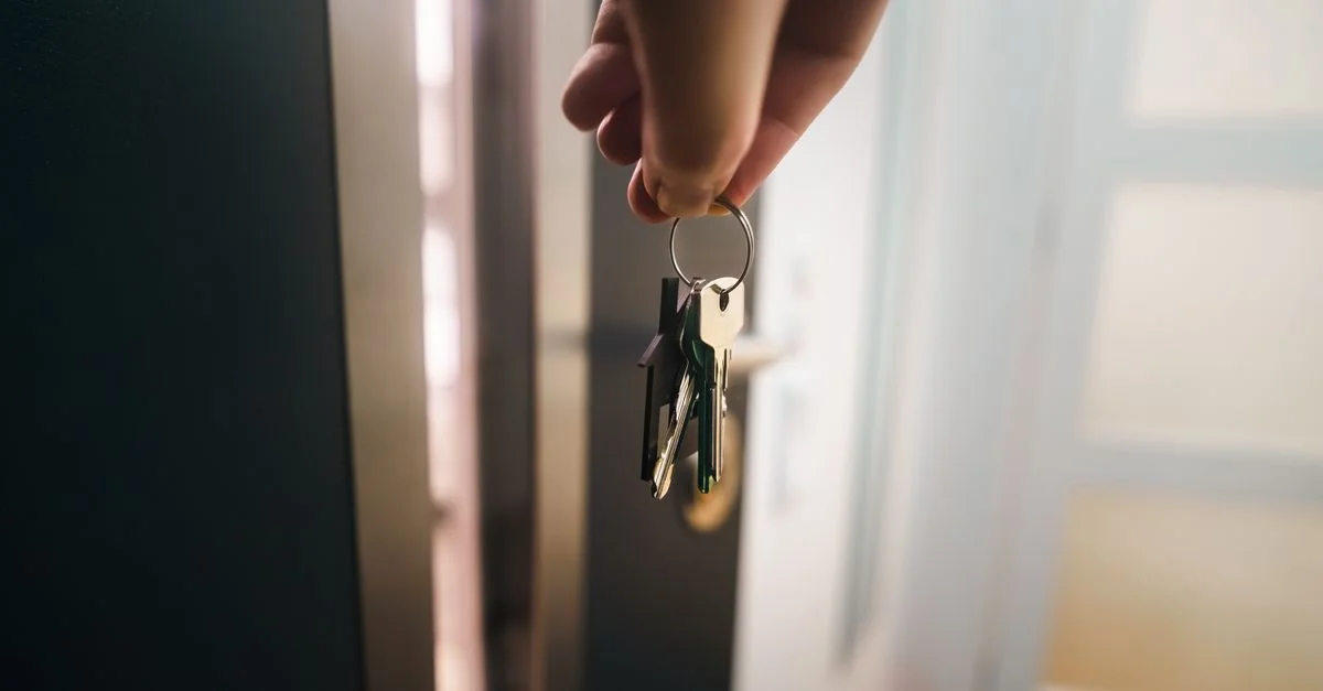 Gros plan d'une main tenant des clés, symbolisant l'accession à la propriété ou l'entrée en location.