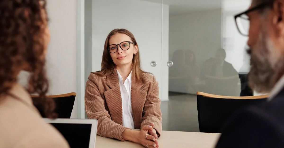 Jeune femme participant à un entretien d'embauche dans un bureau moderne, montrant confiance et professionnalisme.