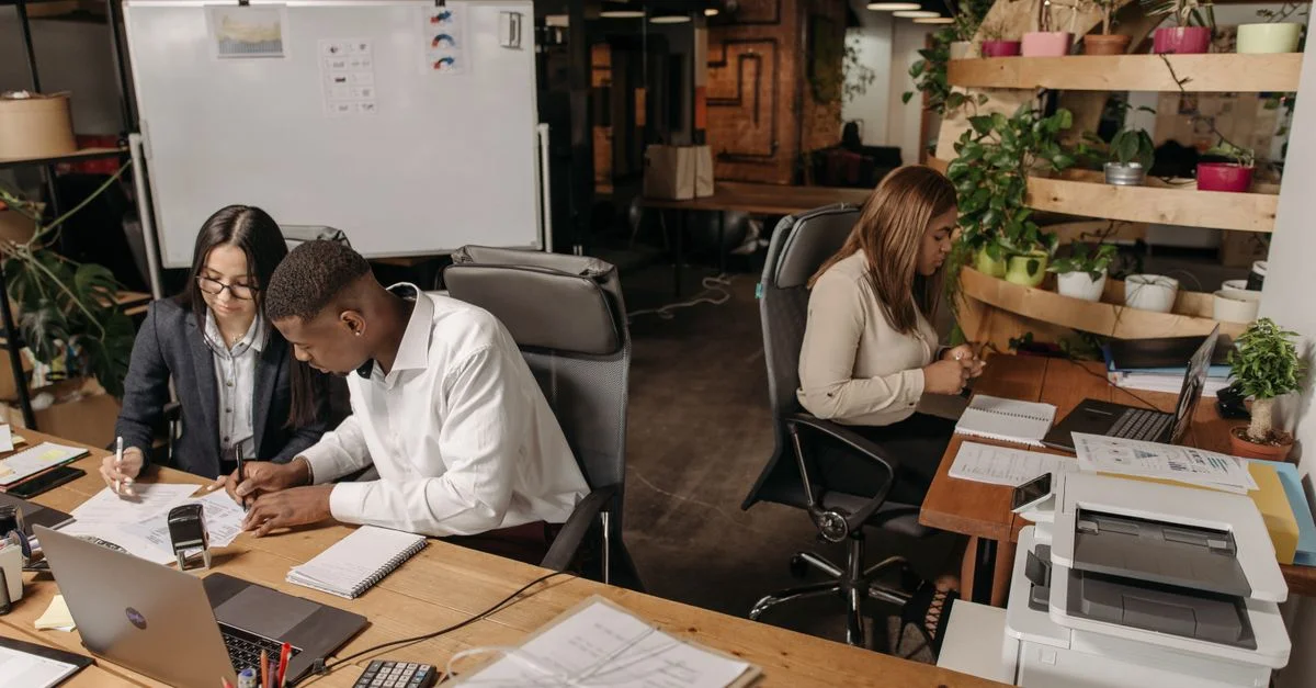 Travail d'équipe dans un bureau moderne avec des collègues divers travaillant ensemble sur des documents.