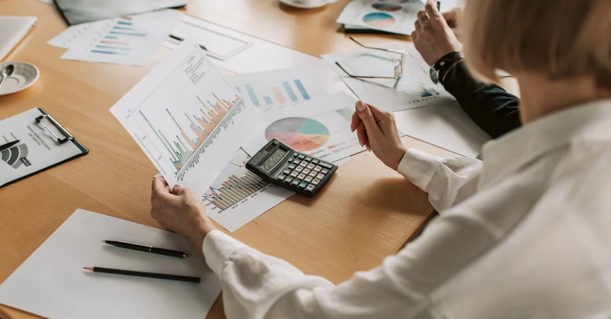Équipe commerciale analysant des données financières et des graphiques lors d'une réunion pour élaborer une stratégie de croissance.