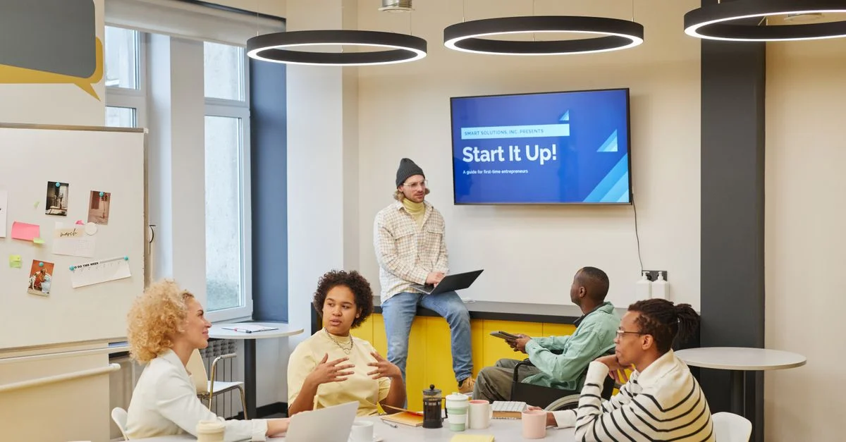 Groupe divers discutant des idées de startup dans un environnement de bureau créatif.