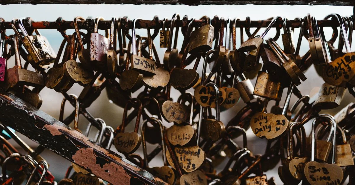 Gros plan de cadenas d'amour attachés à un pont à Paris, symbolisant l'amour éternel.
