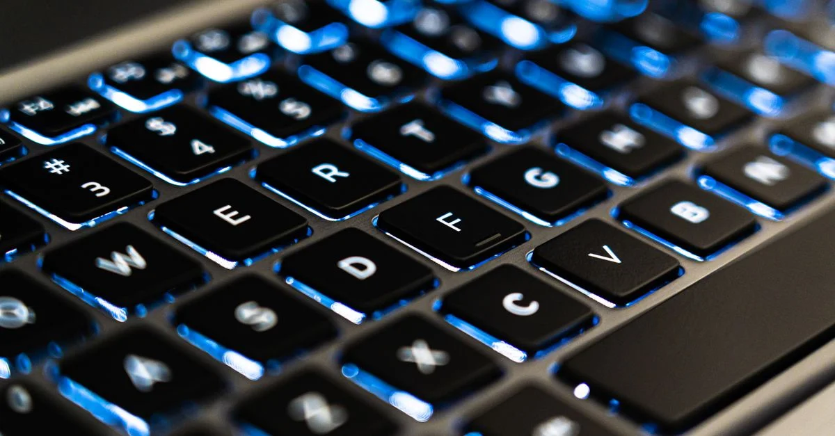 Vue détaillée des touches de clavier d'ordinateur portable rétroéclairées avec éclairage LED bleu pour des concepts technologiques.
