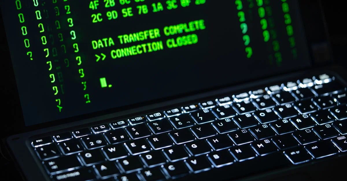 Gros plan sur l'écran d'un ordinateur portable affichant du texte de code vert. Parfait pour les thèmes de cybersécurité.