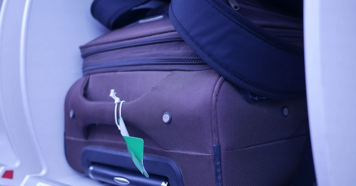Gros plan de bagages dans le compartiment supérieur d'un avion, mettant en avant les essentiels de voyage.