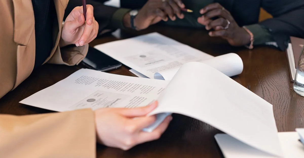 Gros plan de professionnels examinant des documents lors d'une réunion d'affaires dans un bureau.