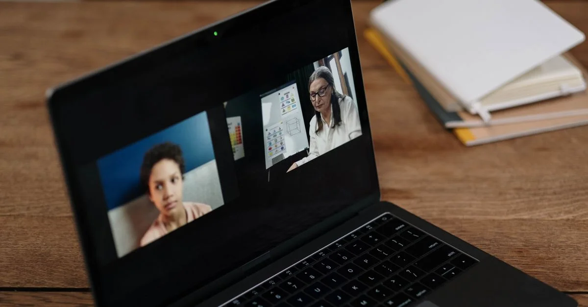 Deux personnes participant à une éducation en ligne via un ordinateur portable, parfait pour illustrer l'apprentissage virtuel.
