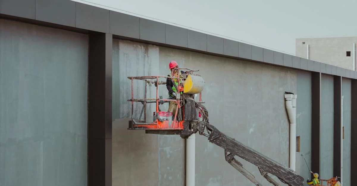 Des ouvriers du bâtiment utilisent une nacelle élévatrice pour l'entretien des bâtiments à Huaian, Jiangsu, Chine.