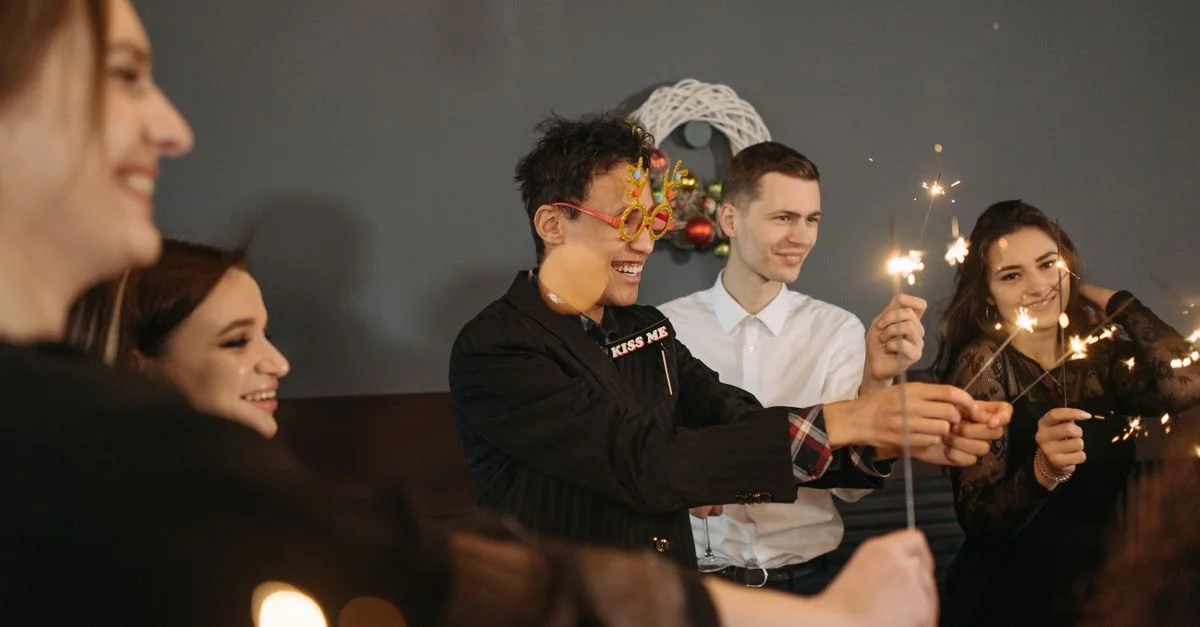 Un groupe d'amis heureux célébrant à l'intérieur avec des étincelles, profitant d'une soirée festive ensemble.