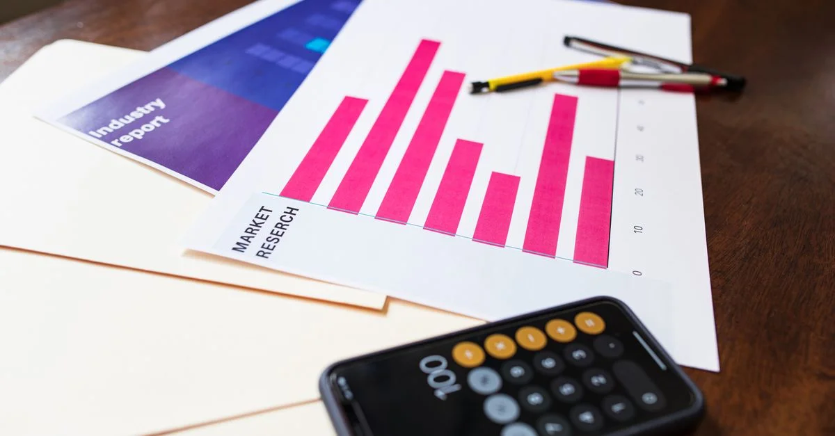 Graphique illustratif de recherche de marché et calculatrice sur un bureau en bois pour analyse commerciale.