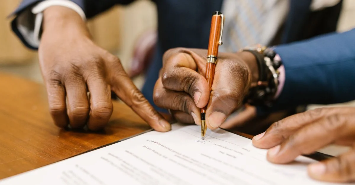 Gros plan de professionnels en affaires signant un contrat légal dans un bureau.