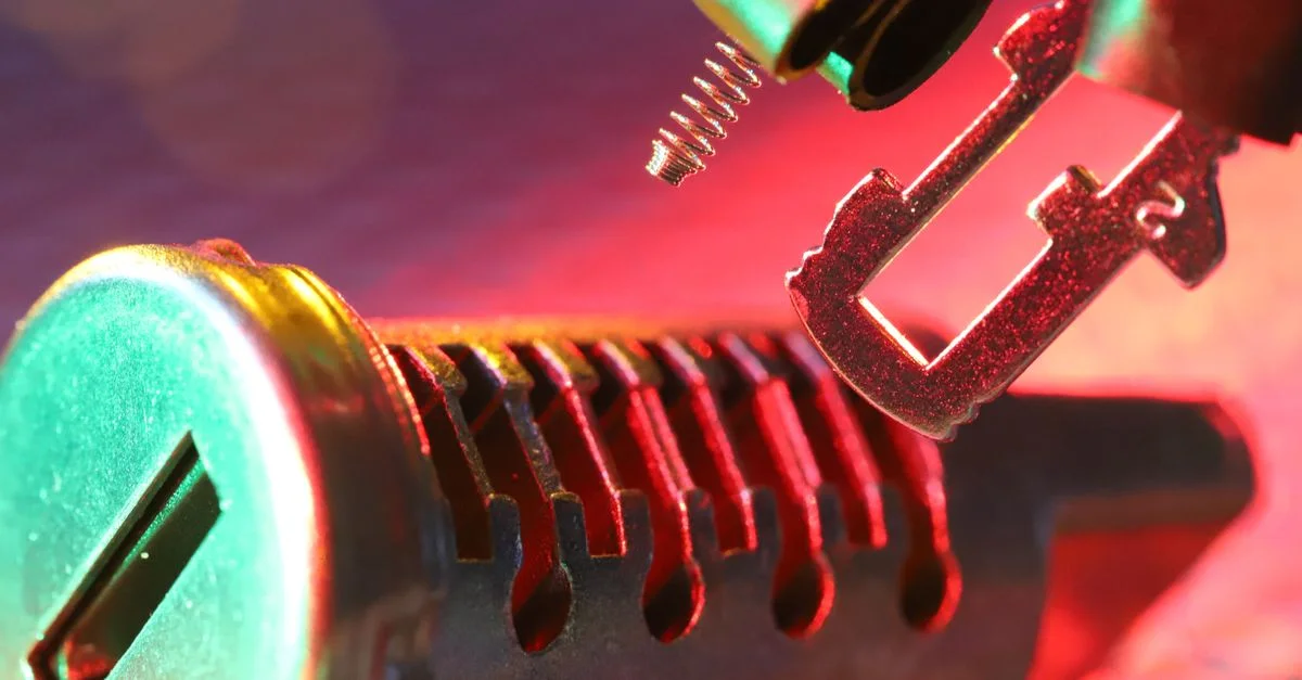 Gros plan d'un cylindre de serrure mécanique et d'une clé, mettant en valeur des composants détaillés sous un éclairage dynamique.