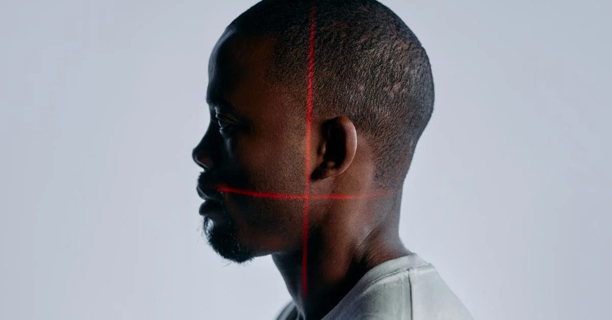 Portrait de profil d'un homme adulte avec des lignes de scan laser sur le visage, mettant en avant une technologie de reconnaissance avancée.