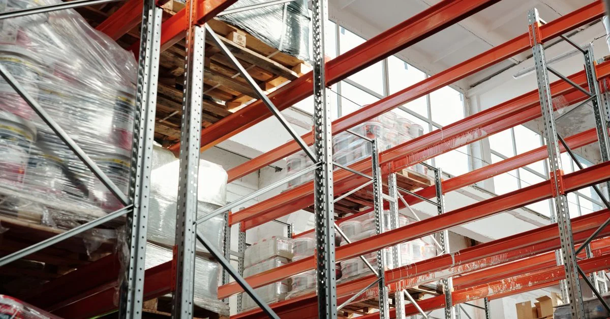 Entrepôt moderne et lumineux avec des palettes et des racks de stockage pour la gestion logistique et d'inventaire.