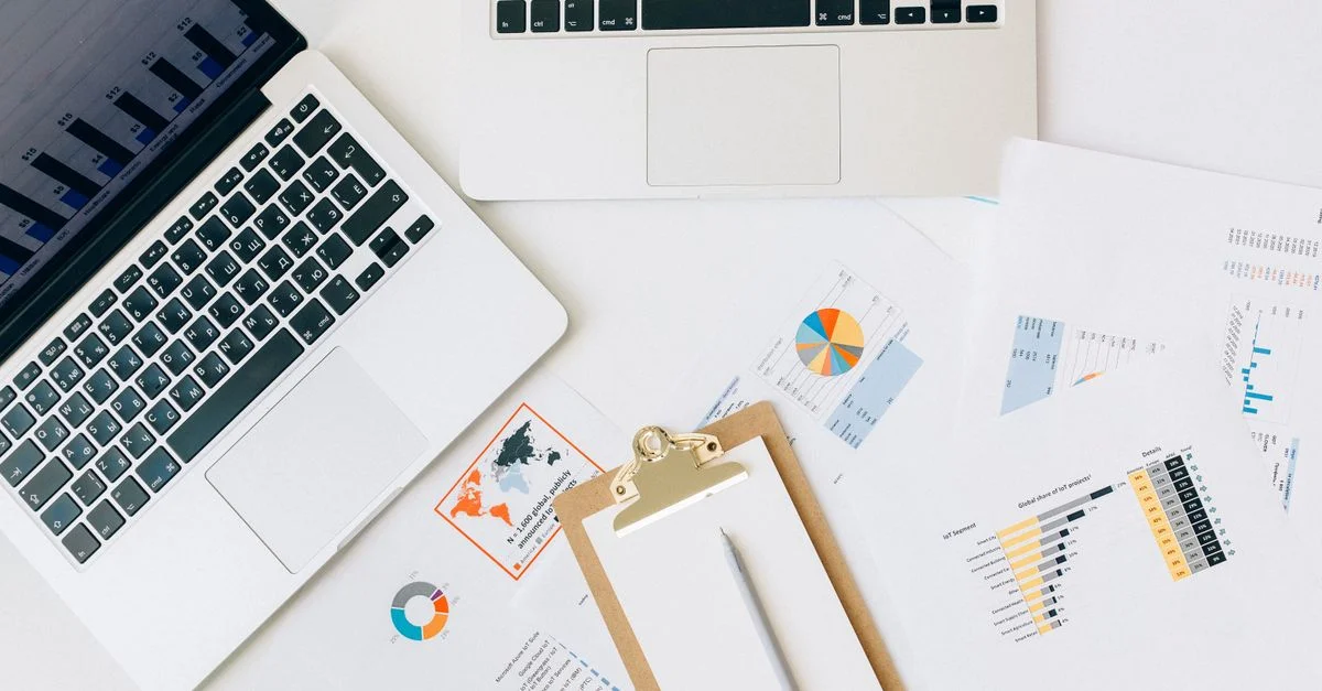 Vue de dessus d'ordinateurs portables, graphiques et rapports utilisés pour l'analyse des données sur un bureau.