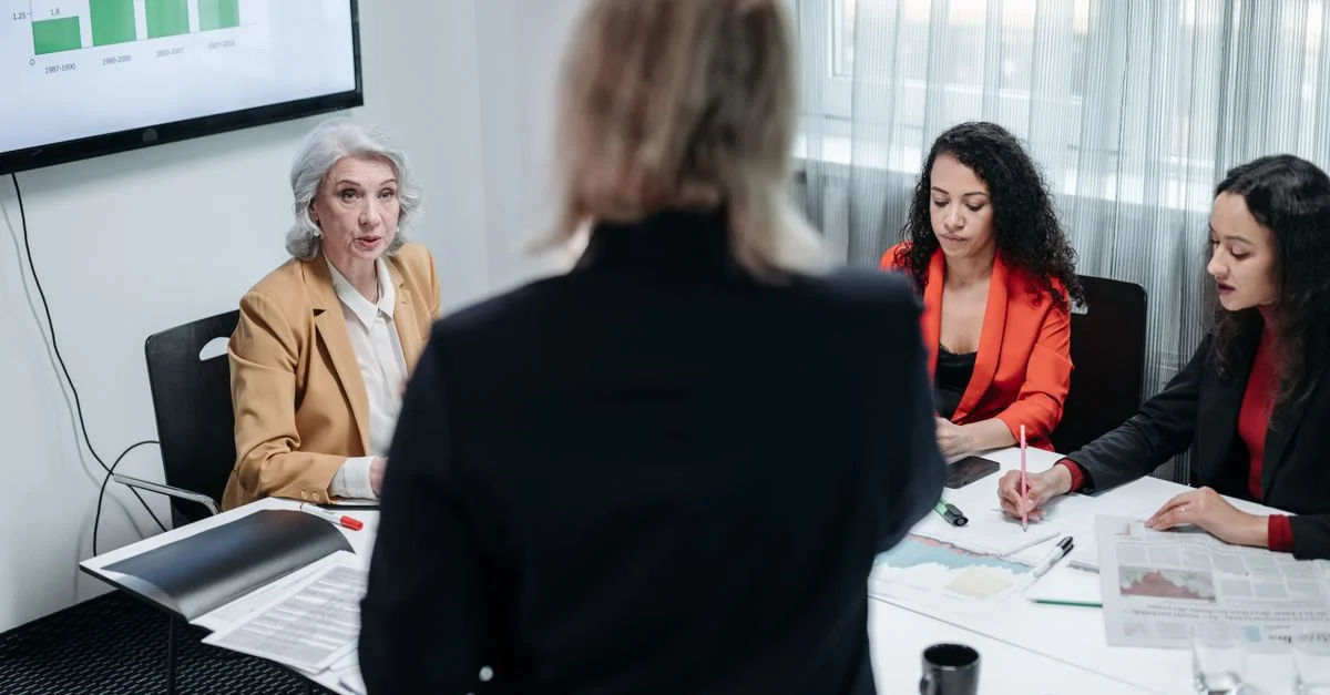 Équipe de professionnels discutant de la stratégie dans un cadre de bureau moderne lors d'une réunion d'affaires.