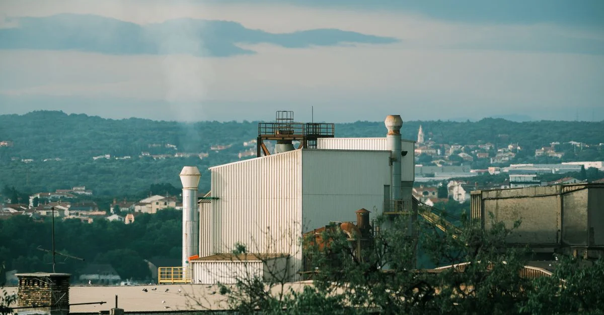 Un bâtiment d'usine se dressant devant le paysage verdoyant pittoresque de la Croatie.