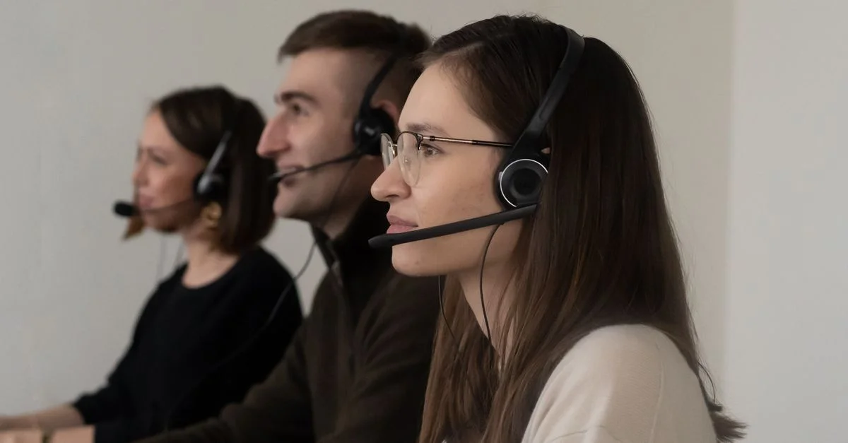 Trois représentants d'un centre d'appels travaillant dans un bureau avec des casques.