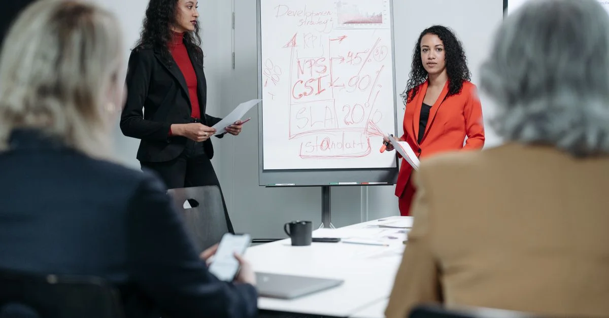 Deux femmes animant une réunion d'affaires axée sur les stratégies KPI et les indicateurs de performance.