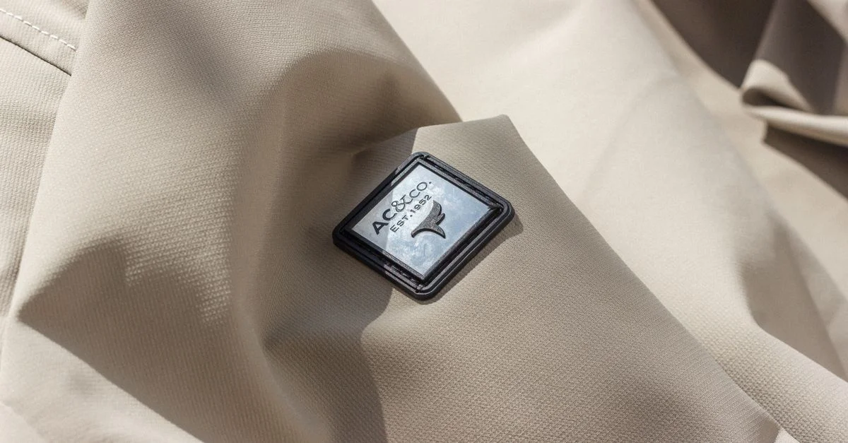 Gros plan sur un tissu beige présentant le logo AC&Co, parfait pour le contenu mode.