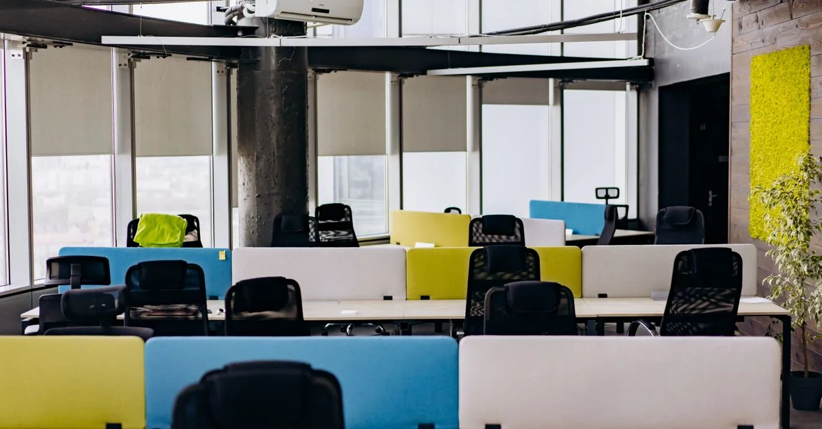 Bureau ouvert lumineux et spacieux avec des bureaux colorés et de la lumière naturelle.