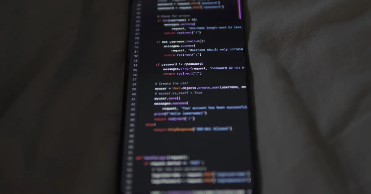 Gros plan sur un smartphone montrant du code Python à l'écran, mettant en avant la programmation et la technologie.