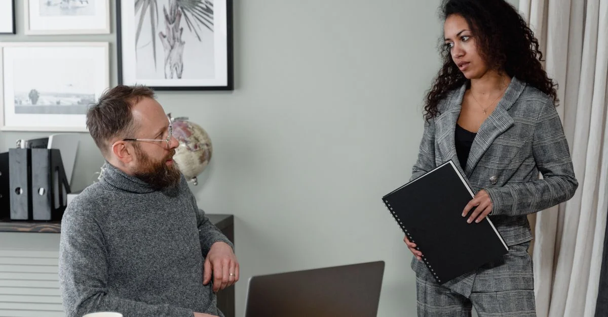 Un homme et une femme discutent de leur travail dans un environnement de bureau stylé avec une décoration moderne.