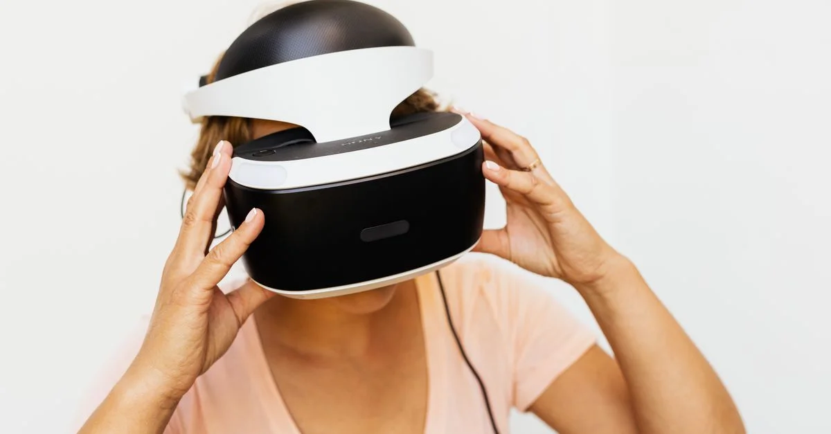 Une femme essayant des lunettes VR, s'engageant avec la réalité virtuelle dans un cadre moderne et minimaliste.