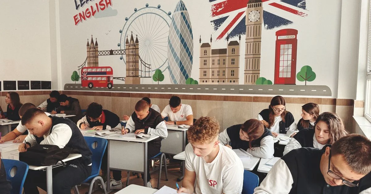 Étudiants étudiant l'anglais dans une salle de classe avec une décoration et une fresque sur le thème britannique.
