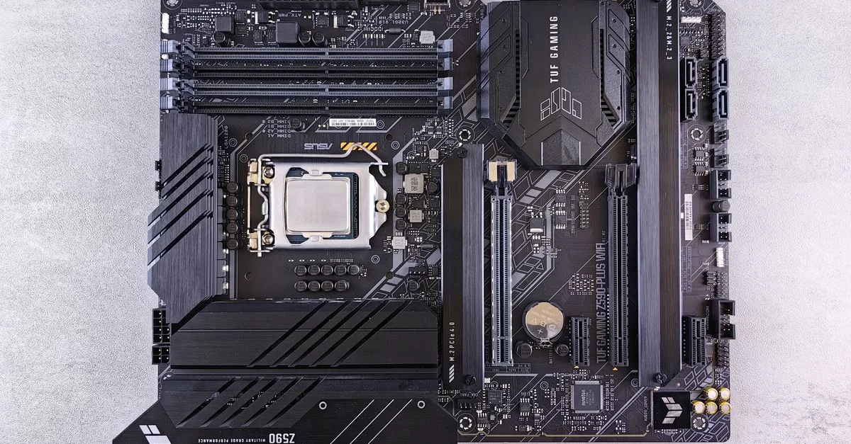 Vue de dessus détaillée d'une carte mère ASUS TUF Gaming Z590 présentant les composants et la conception de haute technologie.