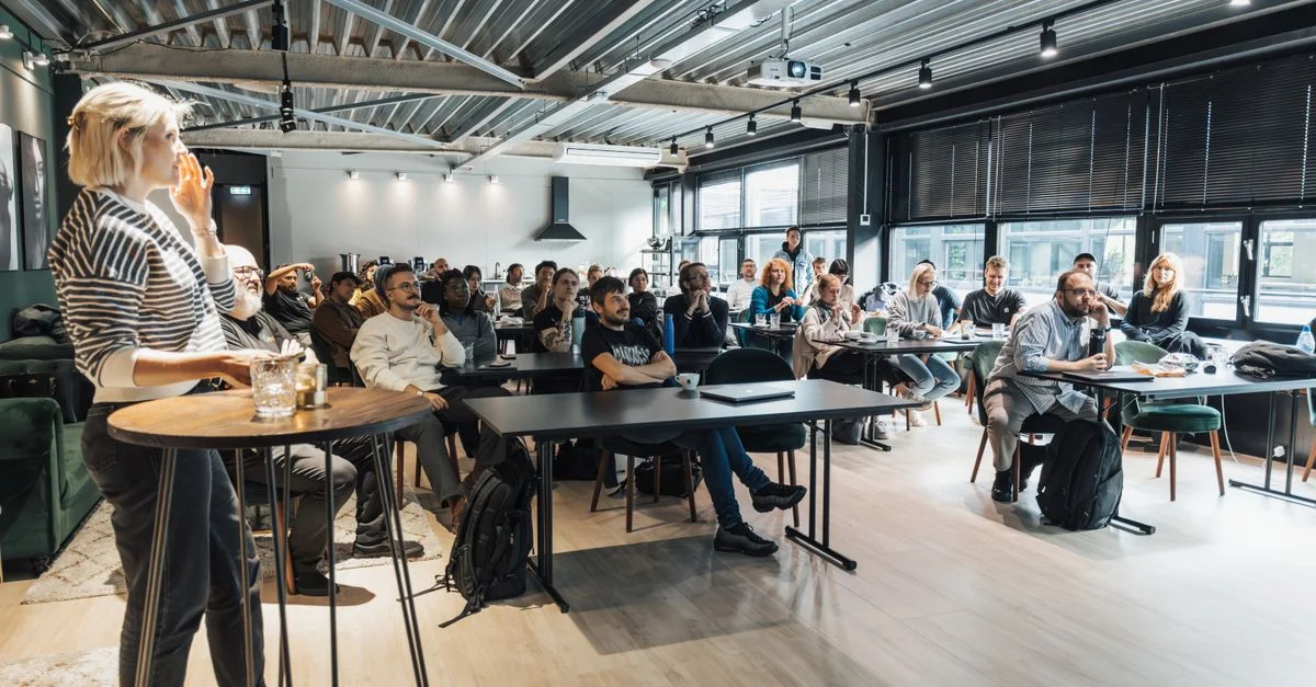 Un atelier d'affaires dynamique engageant un public diversifié dans une salle de conférence moderne.