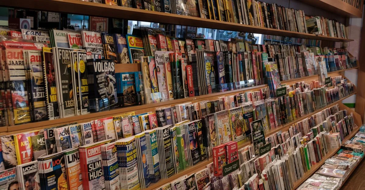 Gamme colorée de magazines dans une librairie d'Amsterdam, présentant une variété de sujets.