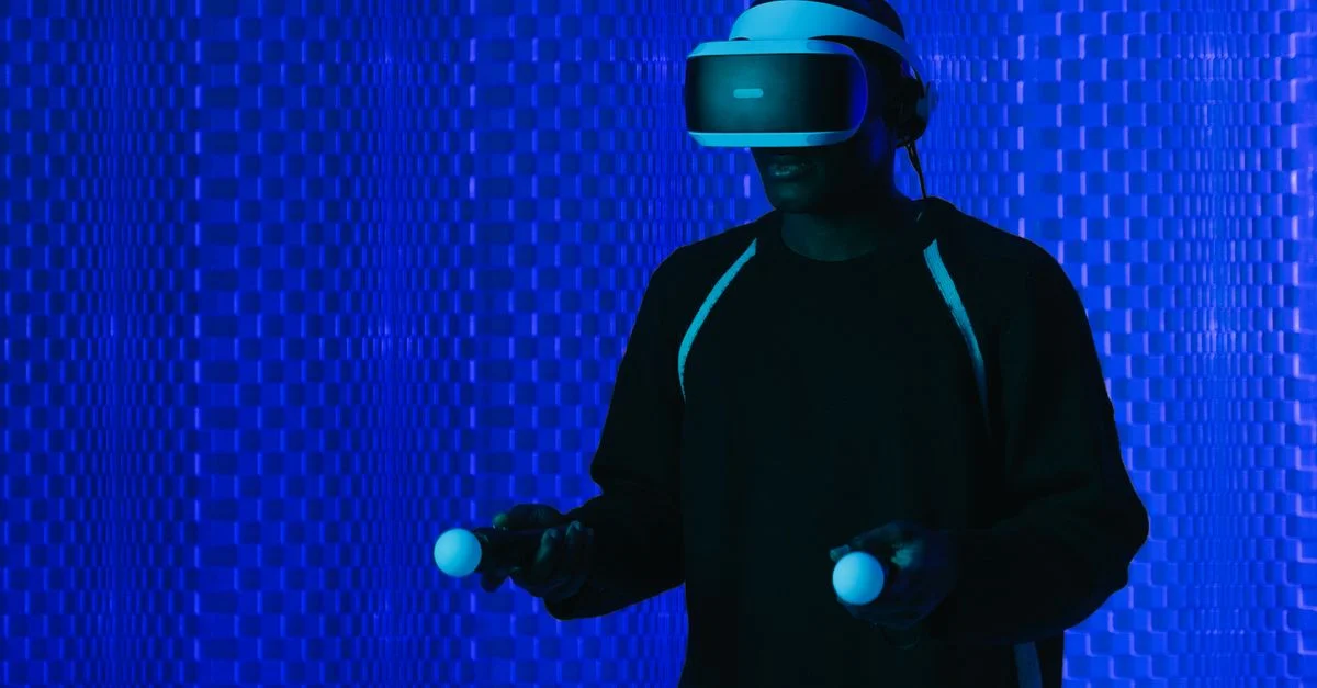 Un homme portant un casque VR et utilisant des contrôleurs, immergé dans un environnement futuriste.