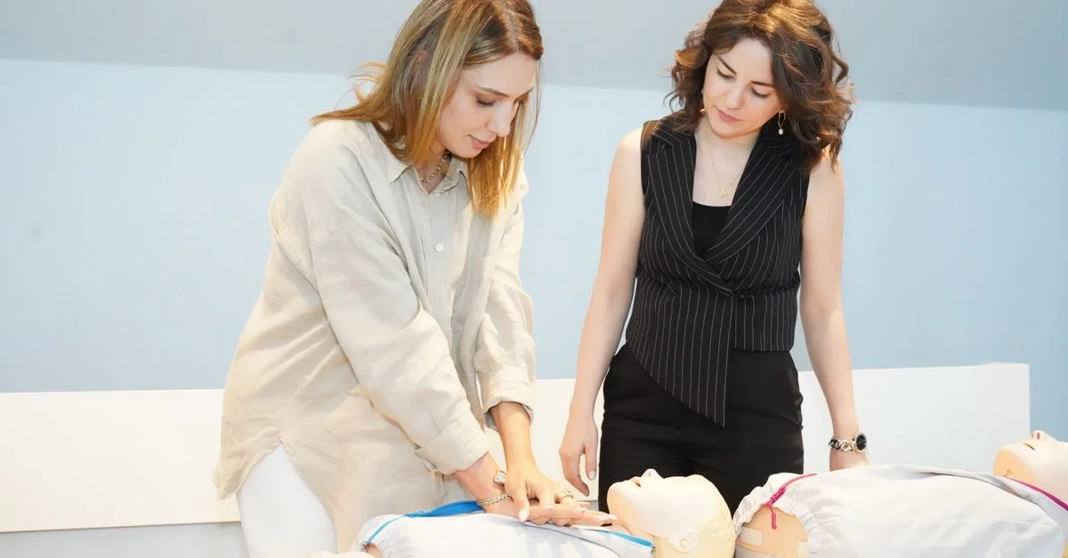 Deux femmes apprennent les techniques de RCR sur des mannequins d'entraînement lors d'un atelier sur les soins de santé.