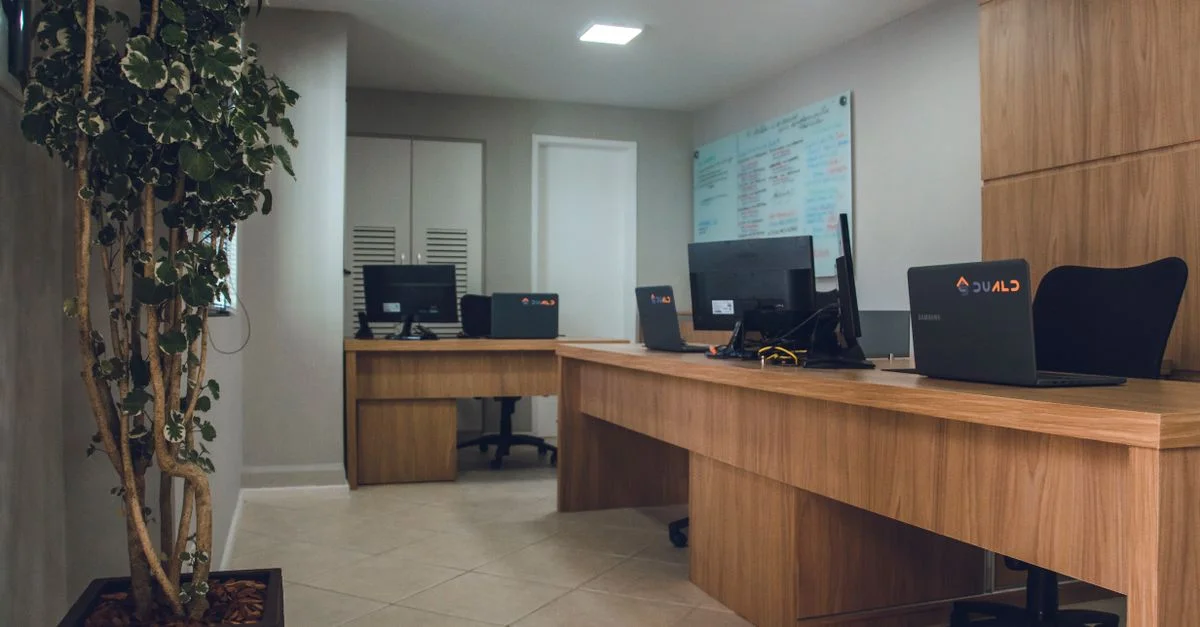 Espace de bureau contemporain avec des bureaux équipés d'ordinateurs et de chaises pivotantes.