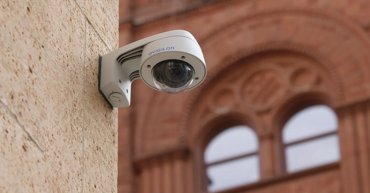 Caméra de sécurité dôme fixée au mur d'un bâtiment municipal, renforçant la sécurité publique.